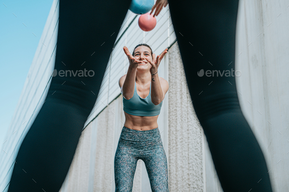Smiling athletic girl doing series of exercises with a medicine