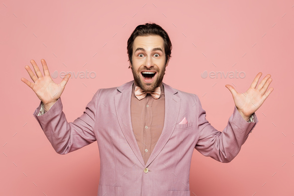 Excited host of event looking at camera on pink background