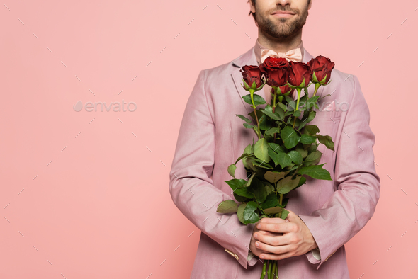 Cropped view of host of event in jacket holding bouquet of roses isolated on pink