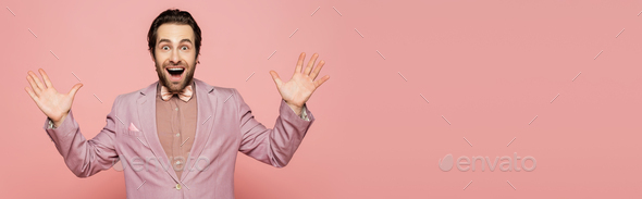 Excited host of event in jacket and bow tie looking at camera on pink background, banner