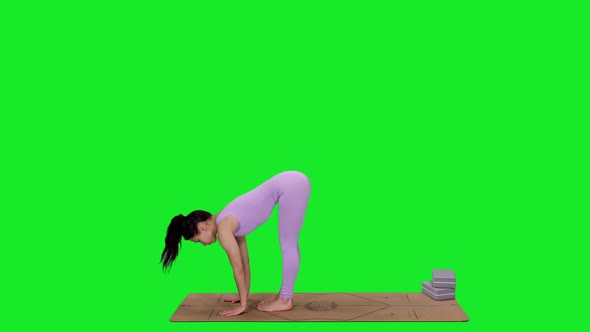 Young Sporty Woman Doing Yoga on Mat Against Green Screen