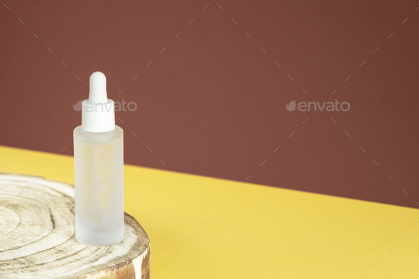 Serum eco cosmetic product on wooden pedestal. Natural cosmetic concept. Beauty skincare essence