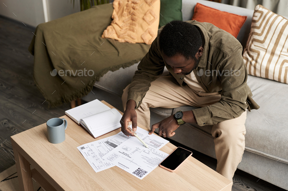 Black man doing taxes at home and filling out documents