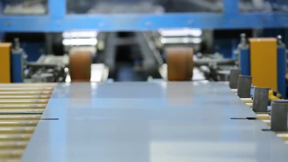 robot arm puts sheet metal into rolling machine alt