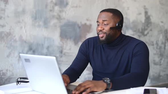 AfricanAmerican Male Employee Using Laptop for Video Call Indoor alt
