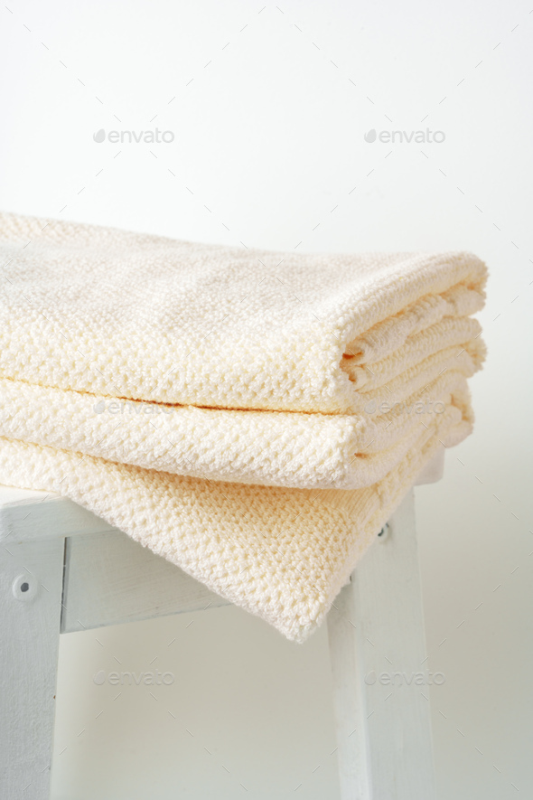 Stacked clean fluffy towels in a bathroom Stock Photo by FabrikaPhoto