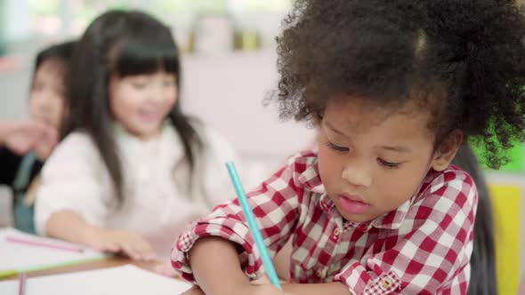 Multi-ethnic young boys and girls happy funny study and play painting on paper at elementary school. alt