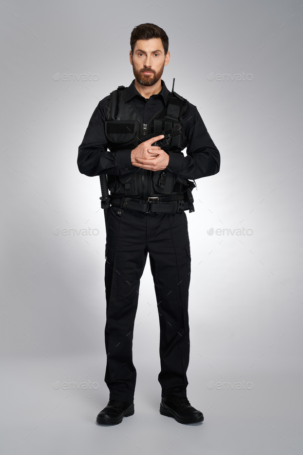 Attractive policeman in body armor, holding gun with both hands. Stock ...