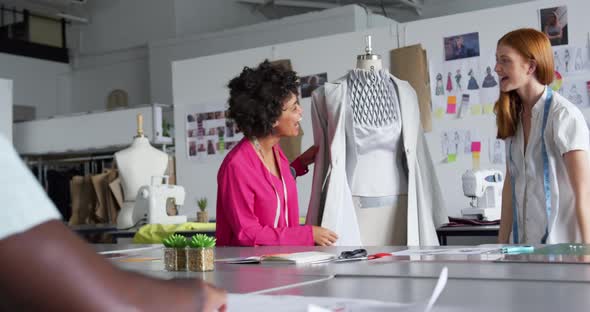 Two women dressing up a model in fashion office alt