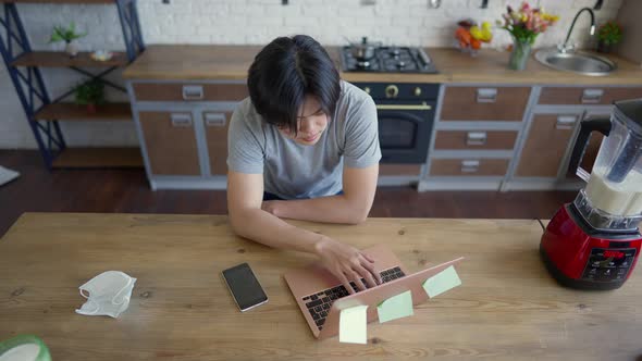Top View of Young Asian Man Typing on Laptop Keyboard Surfing Internet Messaging Online alt