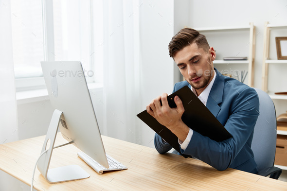 a man in a suit computer desktop work self-confidence paper folder executive
