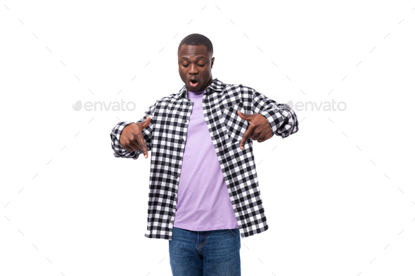 handsome young african man with short haircut in a plaid shirt shows his  hands to the promotional Stock Photo by traimakivan