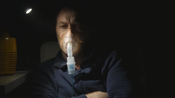 a Man Takes Inhalations Through a Nebulizer