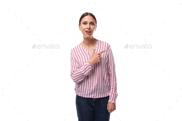 young brunette office worker woman dressed in a shirt points with her hands to the space for