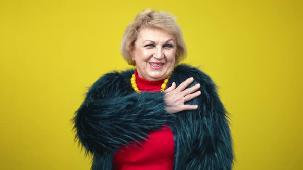 Middle Shot of Cheerful Senior Stylish Woman Dancing on Yellow Background alt