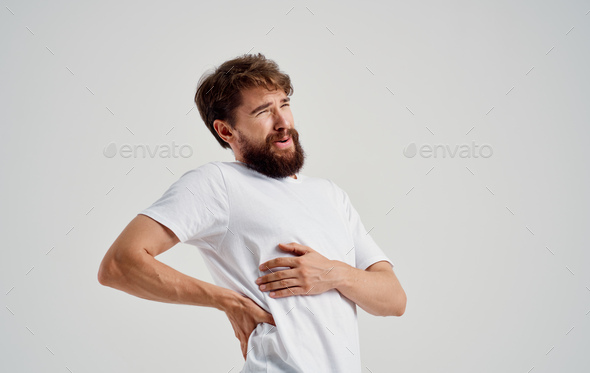 a man touches his back with his hand pain in the spine feeling unwell
