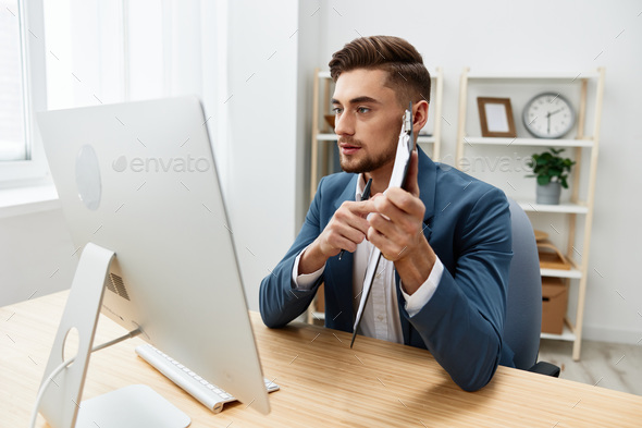 a man in a suit computer desktop work self-confidence paper folder Gray background
