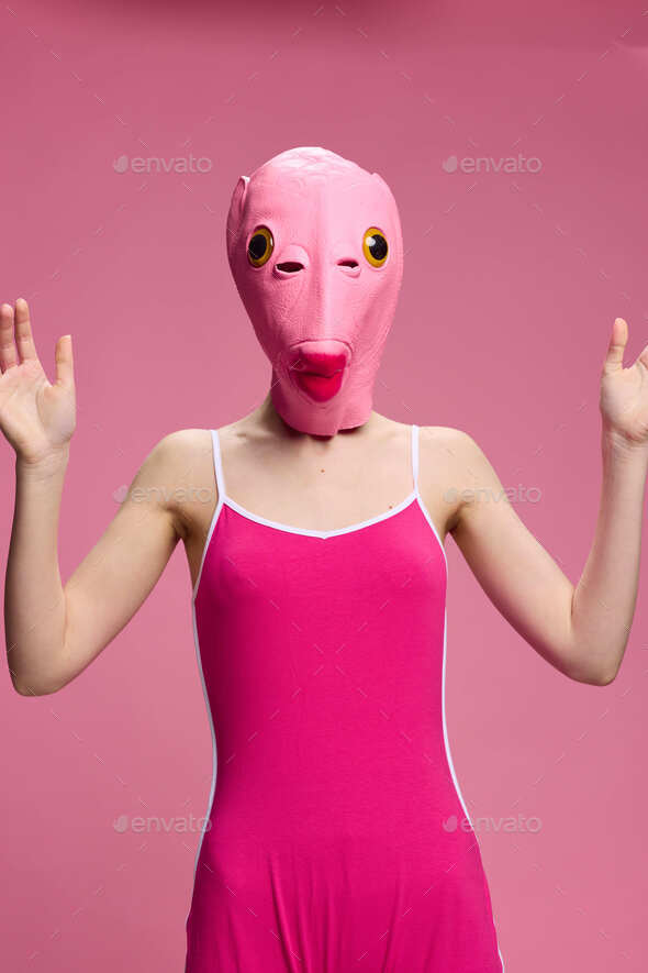 Very strange woman in a pink silicone fish mask for Halloween, crazy image  in pink clothes Stock Photo by shotprime