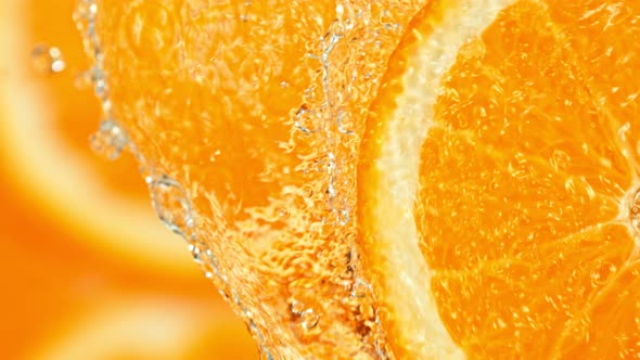 Super Slow Motion Shot of Splashing Water on Rotating Orange Slice at 1000Fps alt
