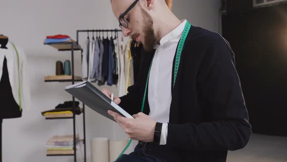 Designer Sits on the Table and Draw Sketches in the Studio alt