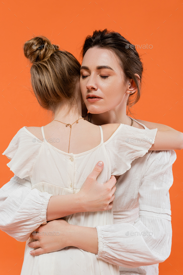 Motherly Love Caring Mother Hugging Daughter On Orange Background