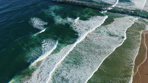 Descending down over waves ,Gold Coast dog beach and sand pumping jetty at sunset alt