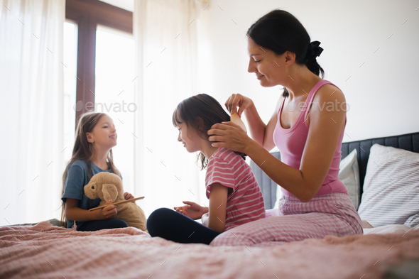 Mother With Two Daughters On A Bed In The Bedroom Mother Combs