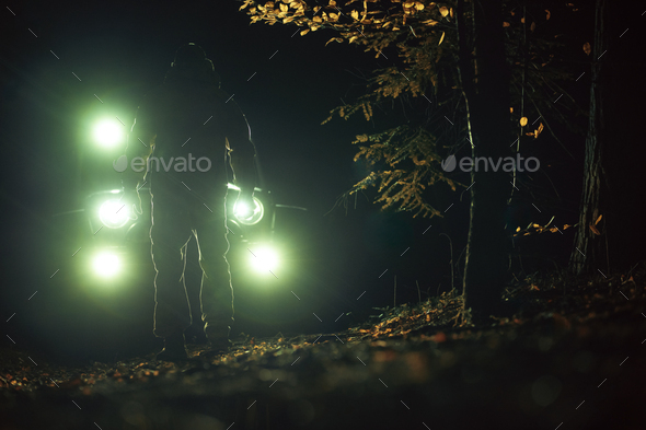 A Man in Front of His Four Wheeler During Night Hours