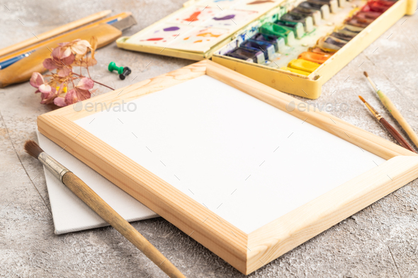 Drawing accessories set: brushes, pencils, watercolor, frame on brown  concrete. Side view Stock Photo by uladzimirz