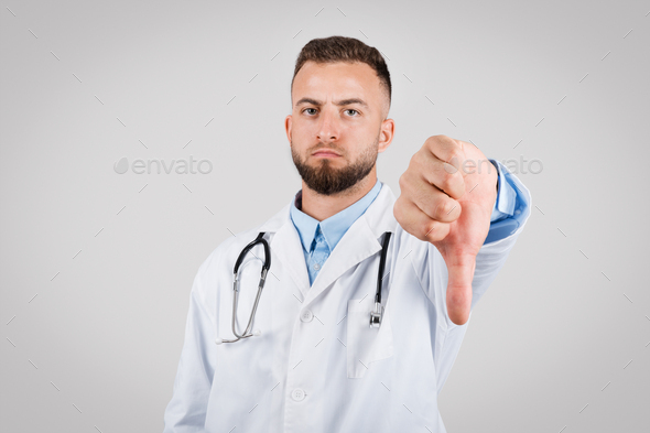 Male doctor showing disapproval with a thumbs-down gesture