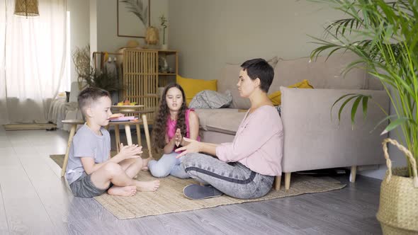 Mother and Children Do Developing Exercises for Fingers