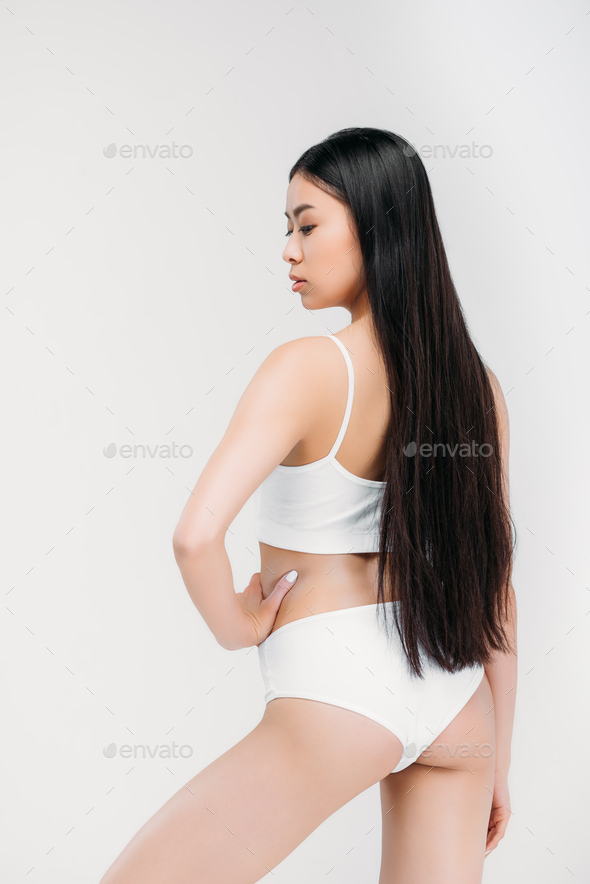 Asian woman taking off or putting bra on white Stock Photo