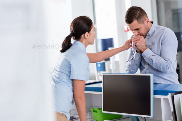 Nurse in blue uniform encouraging upset patient in clinic