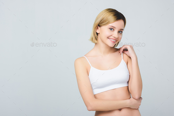 beautiful smiling woman posing in white bra isolated on grey Stock Photo by  LightFieldStudios