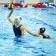 Side view of young female water polo player passing ball to her team - PhotoDune Item for Sale