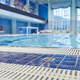 Focus on wet floor of blue poolside with white plastic grid against pool - PhotoDune Item for Sale