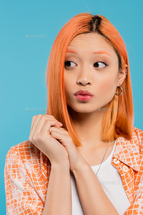 portrait, curious young asian woman with short and dyed hair, natural makeup and hoop earrings