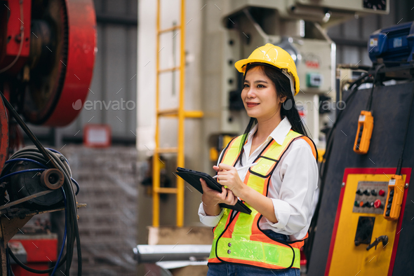 Industrial worker inspecting with tablet machine at factory machines.