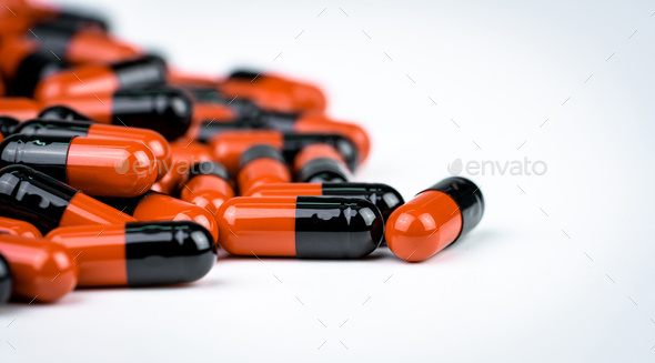 Selective focus on orange-black capsule pills. Antibiotics drug resistance. Drug use with reasonable
