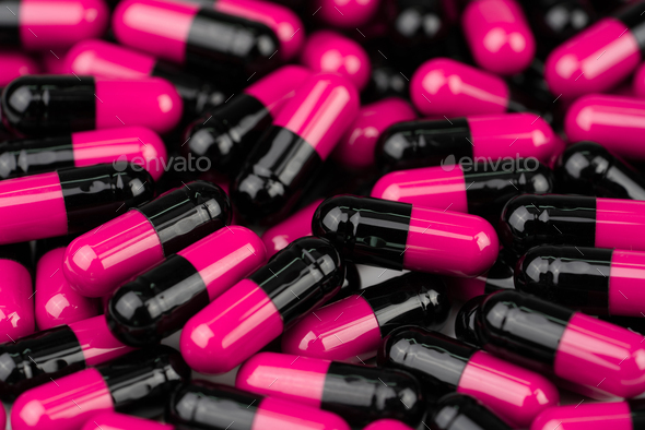 Pile of pink-black capsule pills. Antibiotics resistance. Drug use with reasonable. Global healthy