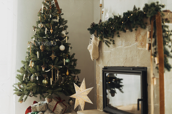 Cozy stockings hanging on mantel and stylish christmas tree in modern farmhouse