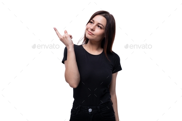 Attractive 25 year old woman points with her hand to the side