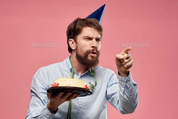 Bearded man with cake on pink background birthday party corporate emotions model loneliness