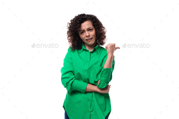 young brunette leader woman dressed in a green blouse points her hand to the side