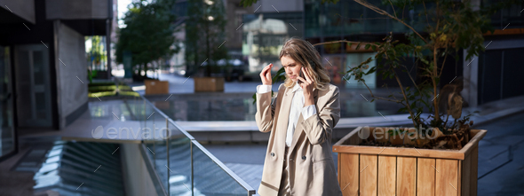 Businesswoman with troubled, worried face talks on mobile phone, has difficult conversation on