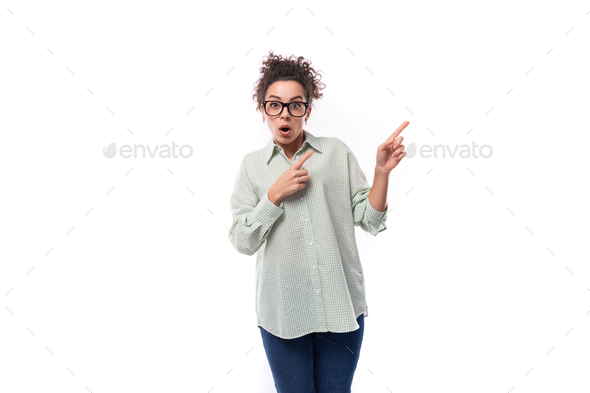 young woman teacher with curly black hair shows her hand to the side
