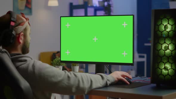 Gamer Playing Video Games on Powerful Computer with Green Screen Desktop alt