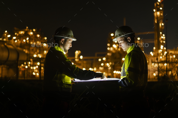 Engineer survey team wear uniform and helmet stand workplace checking blueprint project and radio co