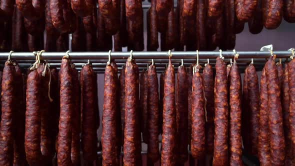 Close Up View of Typical Spanish Dried Sausage Chorizo Hanging on Rack at Meat Processing Plant alt
