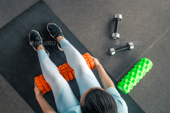 Sport woman using foam roller for muscle and fascia stretching foot. Stock  Photo by puhimec